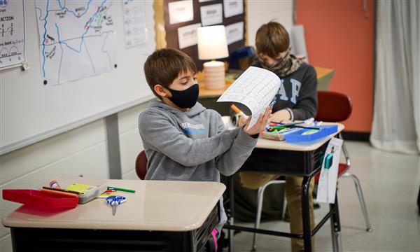 Boy holds up piece of paper